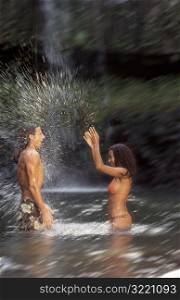 Woman Splashing Man In Tropical Pool