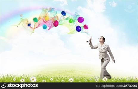 Woman spray balloons. Young woman in suit spraying colorful balloons as celebration concept