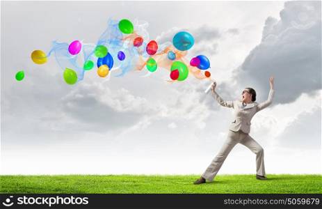 Woman spray balloons. Young woman in suit spraying colorful balloons as celebration concept