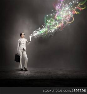 Woman spraying colors. Young businesswoman with suitcase in hand using spray balloon