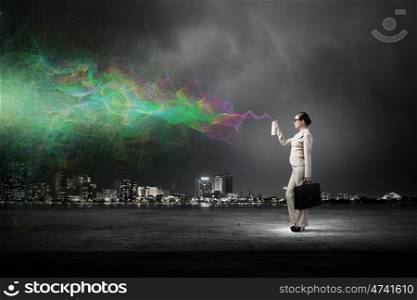 Woman spraying colors. Young businesswoman with suitcase in hand using spray balloon