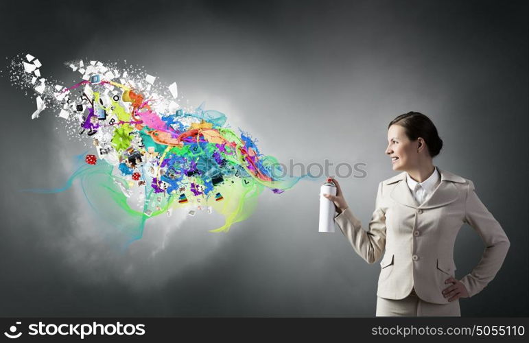 Woman spraying paint. Young businesswoman spraying colorful paint from balloon