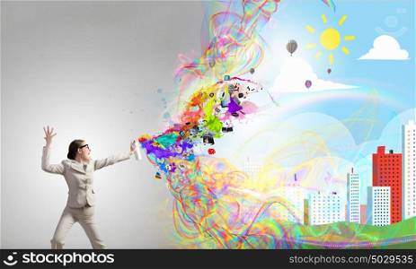 Woman spraying paint. Young businesswoman with suitcase in hand using spray balloon