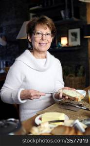Woman spreading butter on a piece of bread