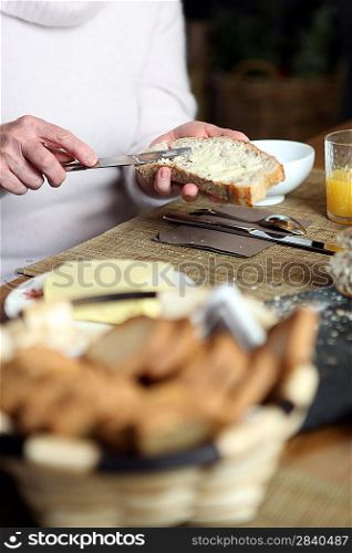 Woman spreading butter on bread