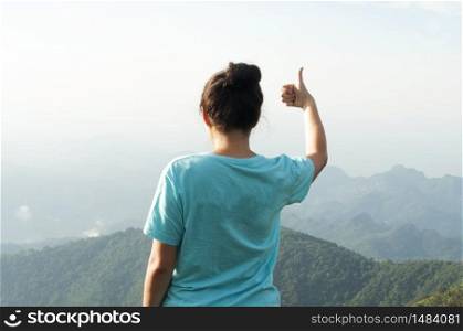 woman stand on top mountain and see view at sunny day. subject is soft focus