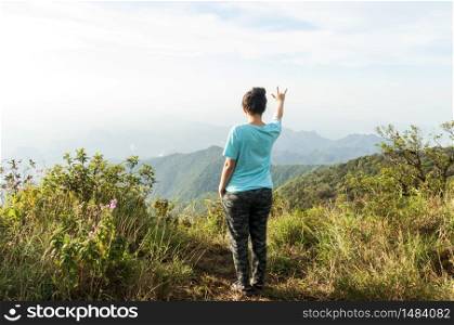 woman stand on top mountain and see view at sunny day. subject is soft focus