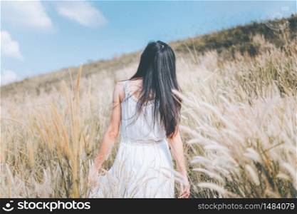 woman stand on white meadow flower with nature background. subject is blurred.