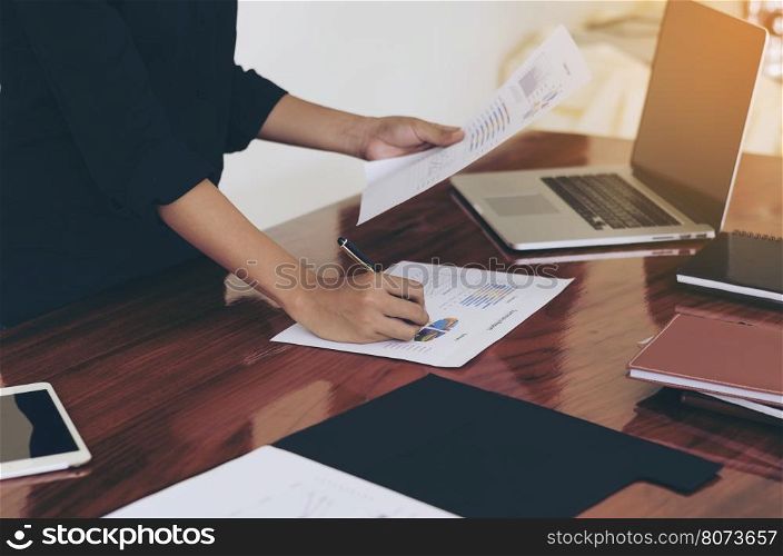 Woman standing at desk and working writing document hand close up