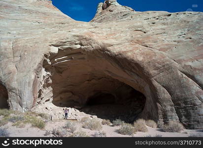 Woman standing at the entrance of Ulrike&acute;s Cave, Amangiri, Canyon Point, Utah, USA