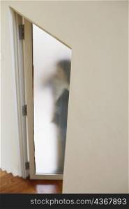 Woman standing behind a door