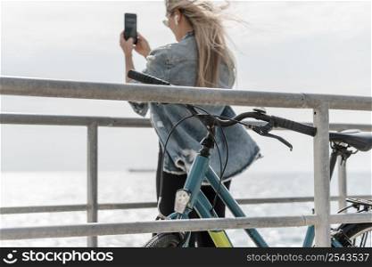 woman standing her bike taking