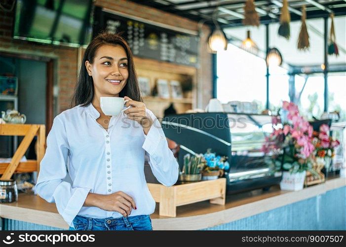 woman standing in a cafe with a cup of coffee