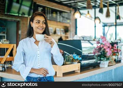 woman standing in a cafe with a cup of coffee