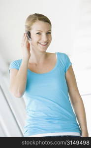 Woman standing in corridor wearing headset and smiling