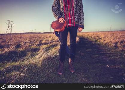 Woman standing in field at sunset