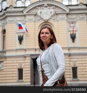 Woman standing in front of a government building, St. Petersburg, Russia