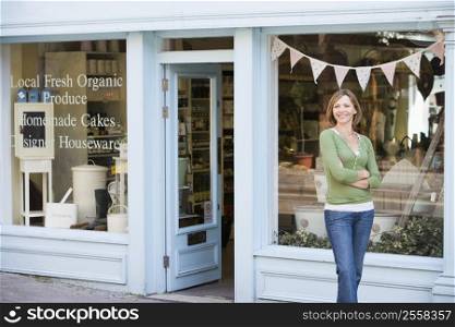 Woman standing in front of organic food store smiling