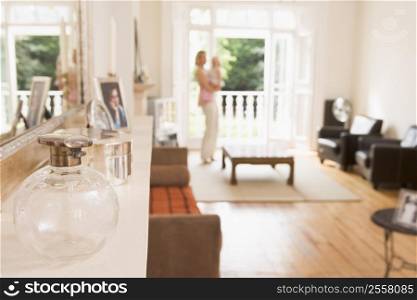 Woman standing in living room holding baby