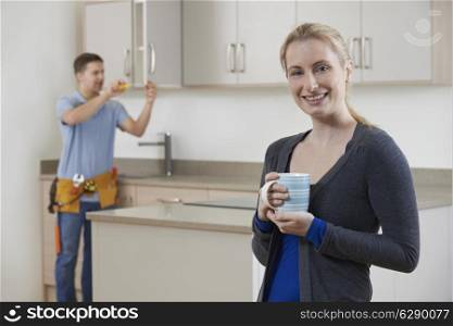 Woman Standing In New Luxury Fitted Kitchen