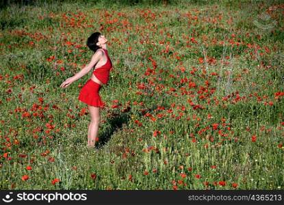 Woman standing in poppy field