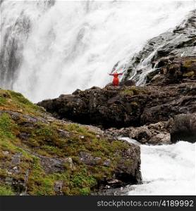 Woman standing near a waterfall, Kjosfossen, Aurland, Fjordane County, Norway