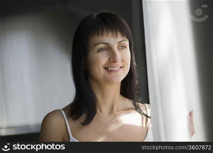 Woman standing near window in natural light