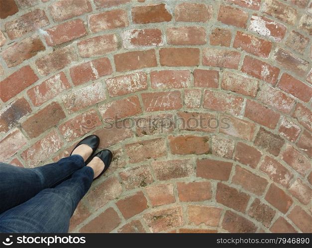 woman standing on a circular, brick patio