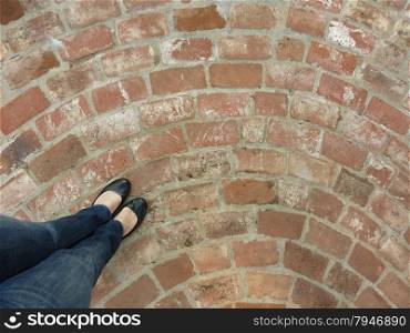 woman standing on a circular, brick patio