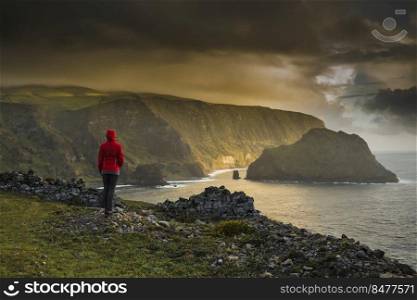 Woman standing on a top of a clif and enjoying the view, Azores Island.