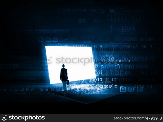 Woman standing on big laptop. Rear view of businesswoman with suitcase standing on keyboard of big laptop