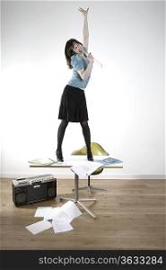 Woman standing on desk and singing
