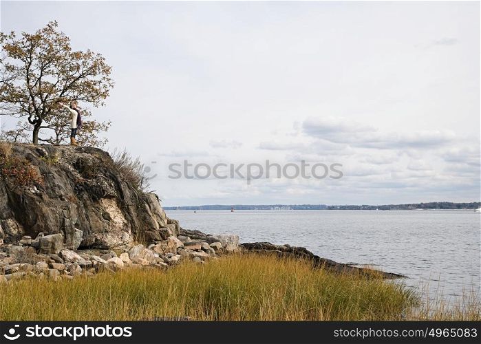 Woman standing on rocks near a lake