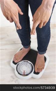 Woman Standing On Scales With Fingerrs Crossed