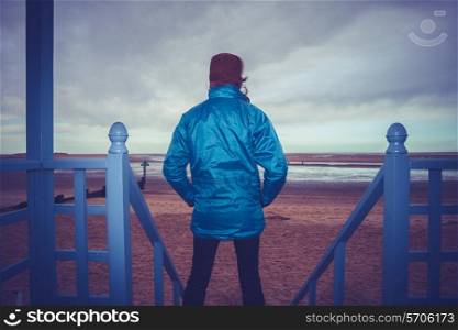 Woman standing outside beach hut in the winter