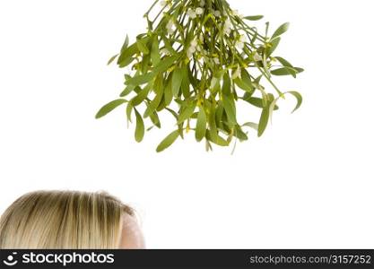 Woman Standing Under Bunch Of Mistletoe Against White Background
