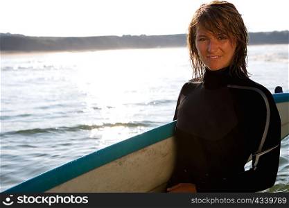 Woman standing with a surfboard