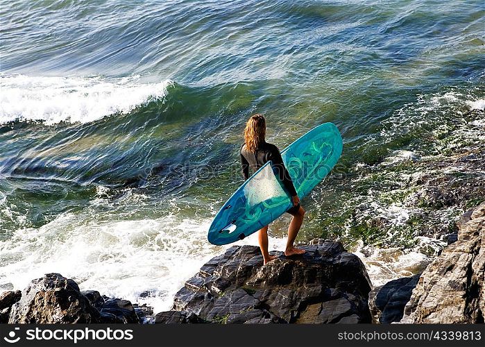 Woman standing with a surfboard