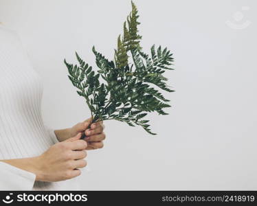 woman standing with fern leaves