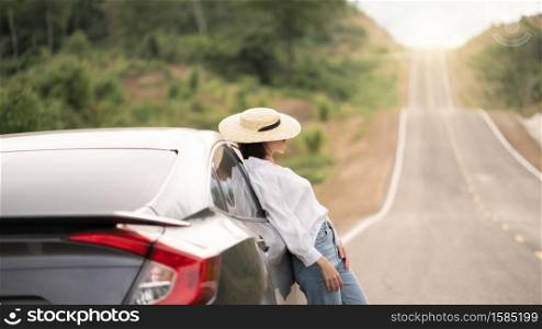Woman standing with the car. pose with car in beautiful empty rural curve, asphalt road way.