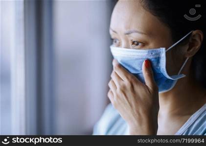 Woman staying at home wearing protective surgical mask