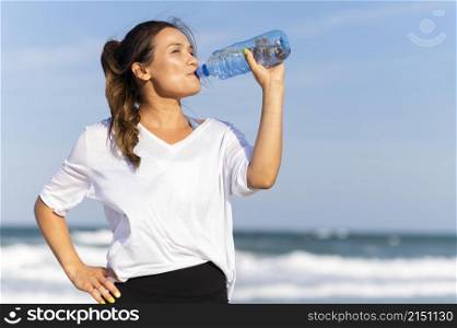 woman staying hydrated beach while working out