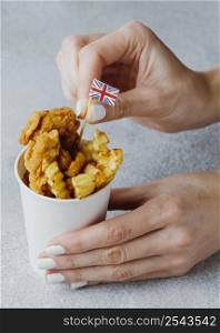 woman sticking great britain flag fish chips dish paper cup