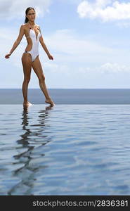 Woman stood by infinity pool