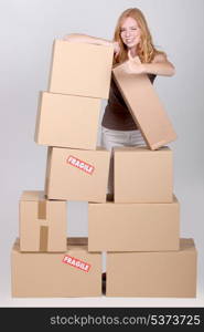 Woman stood by pile of cardboard boxes