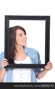 Woman stood holding empty picture frame