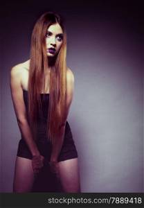 Woman straight long hair make-up posing in studio dark background