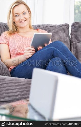 Woman Streaming Music From Digital Tablet To Wireless Speaker
