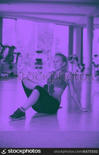 woman stretching and warming up for her training at a gym. Cute young woman stretching and warming up for her training at a gym duo tone