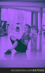 woman stretching and warming up for her training at a gym. Cute young woman stretching and warming up for her training at a gym duo tone